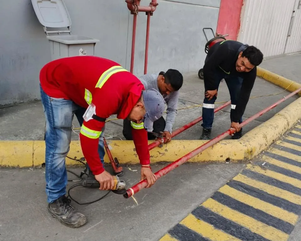 Técnicos instalando red de tuberías CI con rociadores en techo